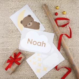 Klistermærker til dør på et ark med en bjørn, der sover på en måne, og en sky med teksten "Noah", omgivet af julegavepapir.