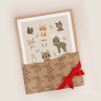 Plakat med skovdyr i ramme, pakket ind i julepapir med en sløjfe på.