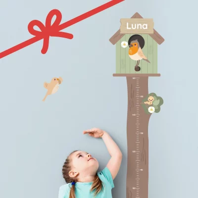 Barn der måler sin højde ved et højdemåler-træ med fuglehus og navnet ”Luna”.
