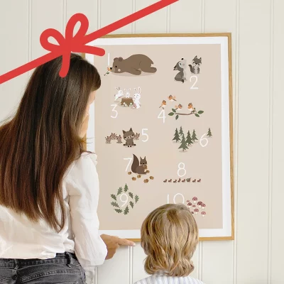 Voksen og barn der ser på en talplakat med skovdyr på væggen.