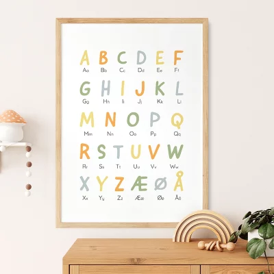 Alfabetplakat til børneværelset i ramme, farverig og lærerig vægdekoration ved siden af hylde med dekor fra et stilrent barnerumsmiljø.