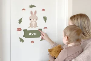 Mor og barn peker på en dørdekor med kaninmotiv og navnet Ava, perfekt som personlig dekorasjon for barnerommet.