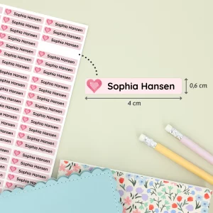 Navnelapper med navnene Sophia Hansen i et farverigt design med hjerte. Hver label måler 4 cm x 0,6 cm og præsenteres på en bagegrund med blyanter og dekorative papirvarer. Ideelt til at personalisere børns ejendele.